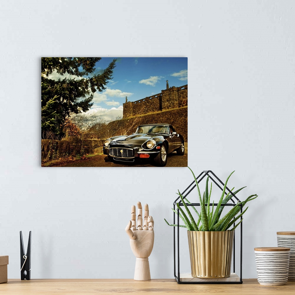 A bohemian room featuring HDR photo of a vintage car parked near a fortress in a desert.