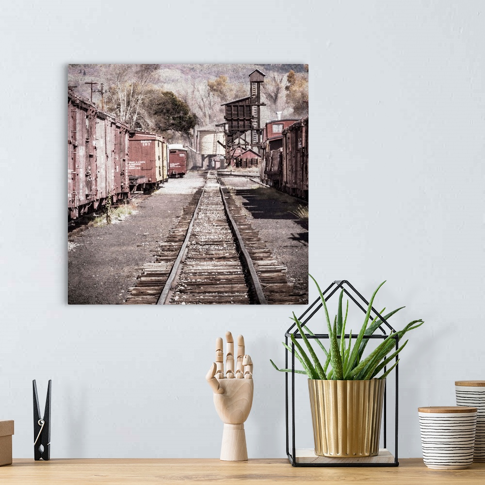 A bohemian room featuring Photograph of a railroad passing through an old train yard.
