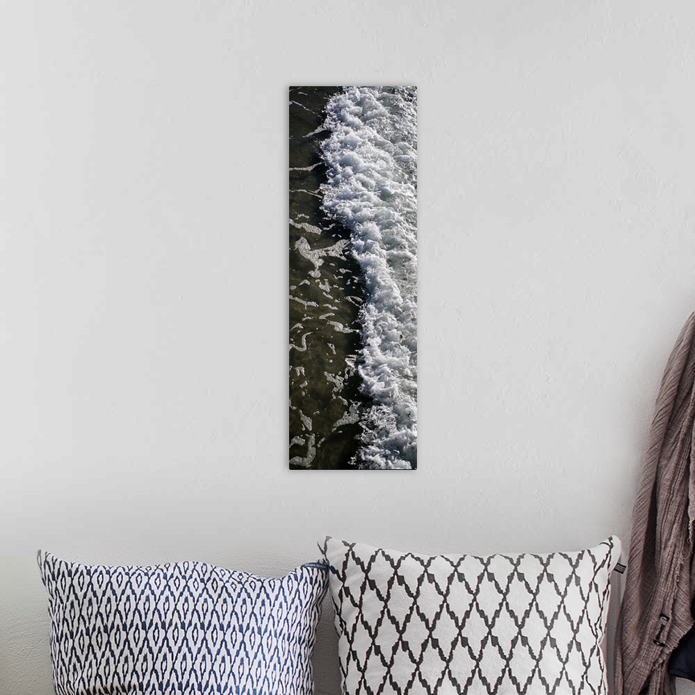 A bohemian room featuring Tall, panoramic photograph of the white water from a crashing wave onto the shore.