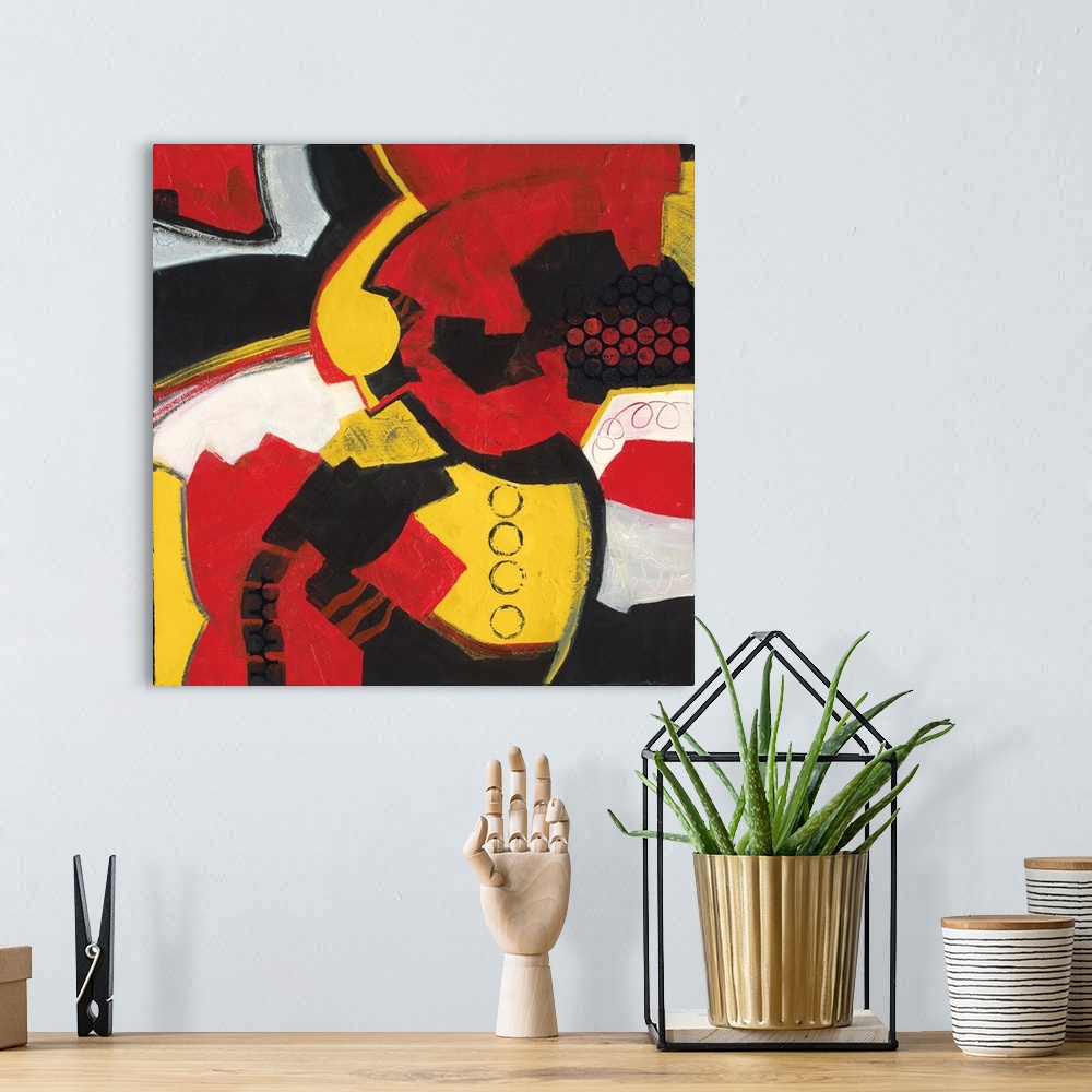 A bohemian room featuring Square abstract painting with bold red, yellow, black, and white hues.