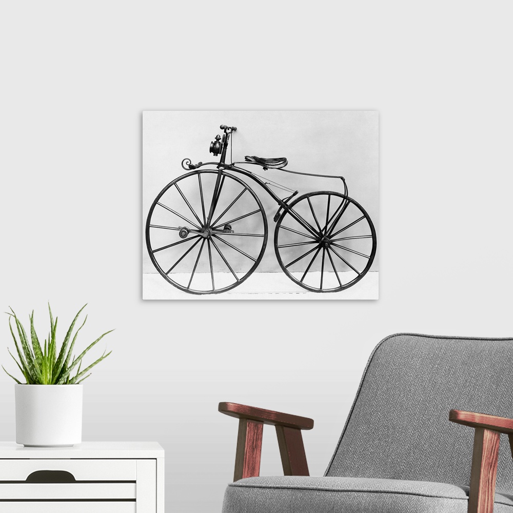 A modern room featuring An early bicycle, known as a bone shaker.