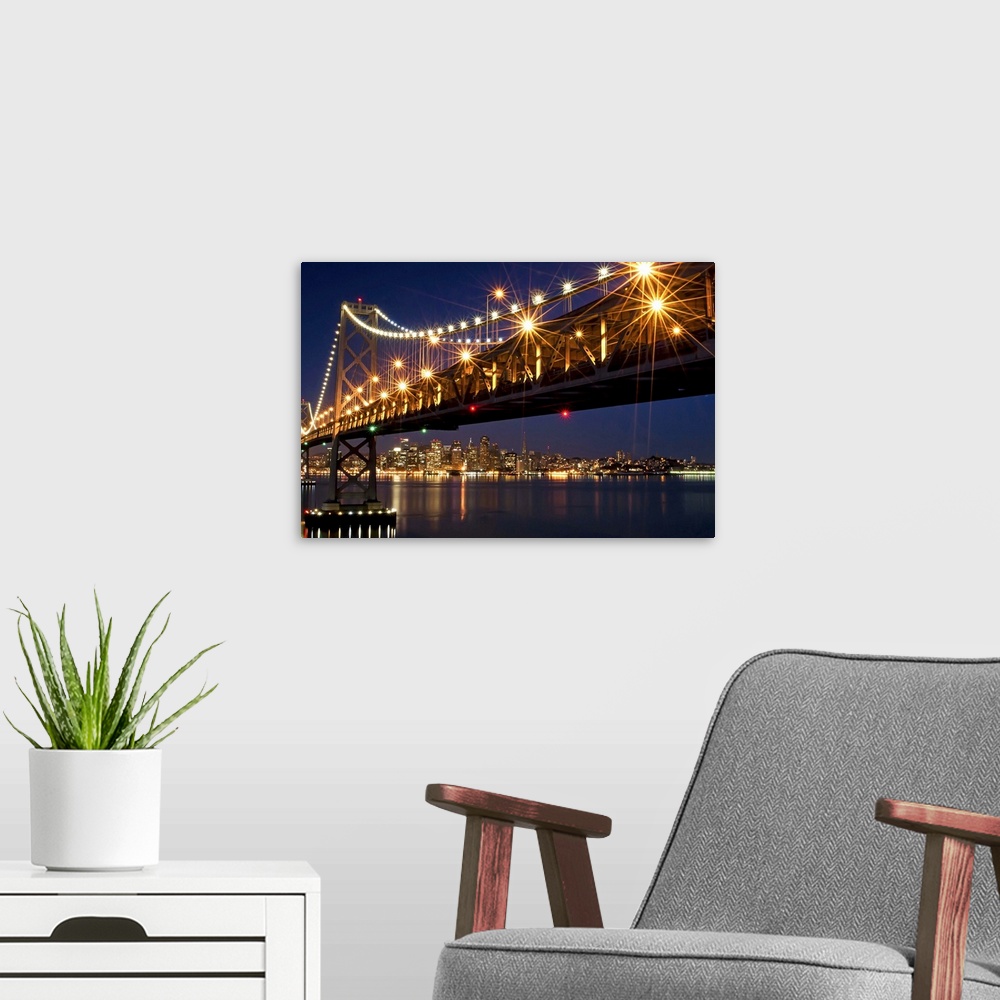 A modern room featuring A burst of lights on the Bay Bridge and San Francisco skyline in the background.