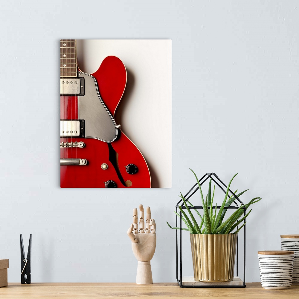 A bohemian room featuring A close up of an electric guitar showing its shape and design.