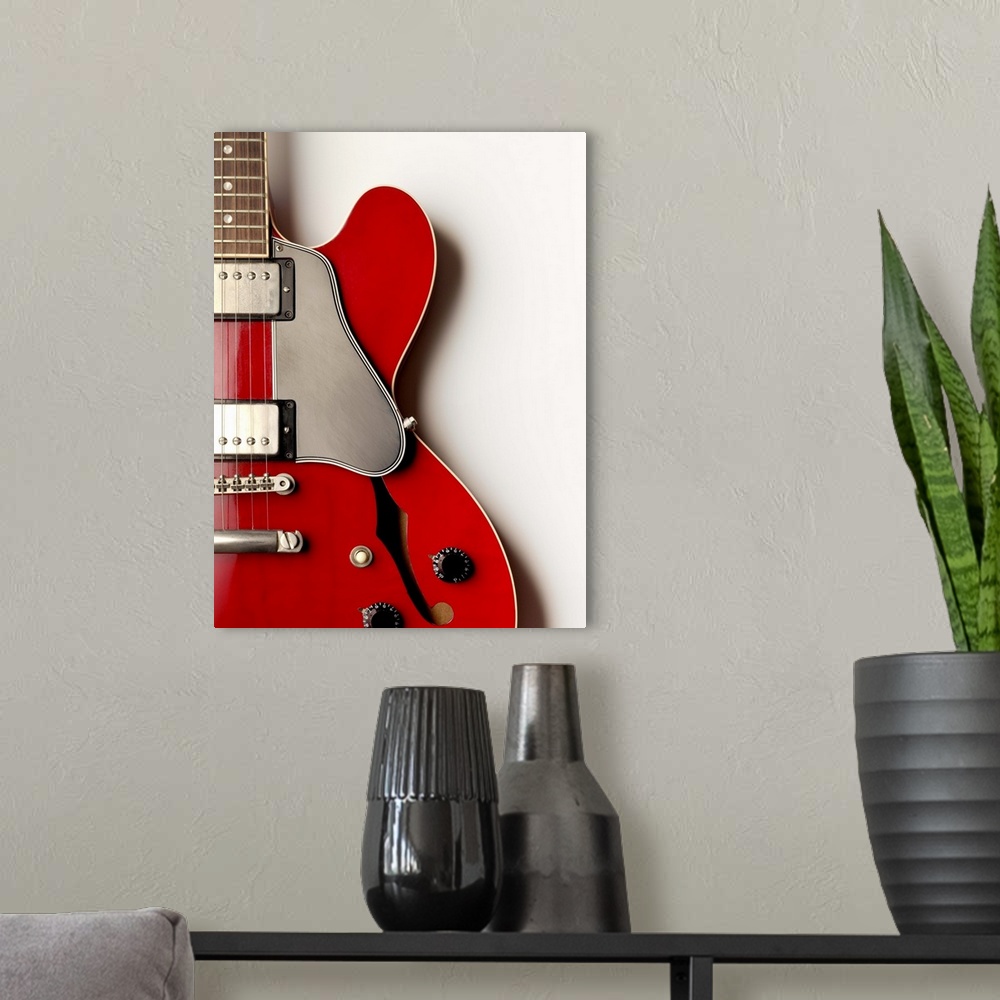 A modern room featuring A close up of an electric guitar showing its shape and design.
