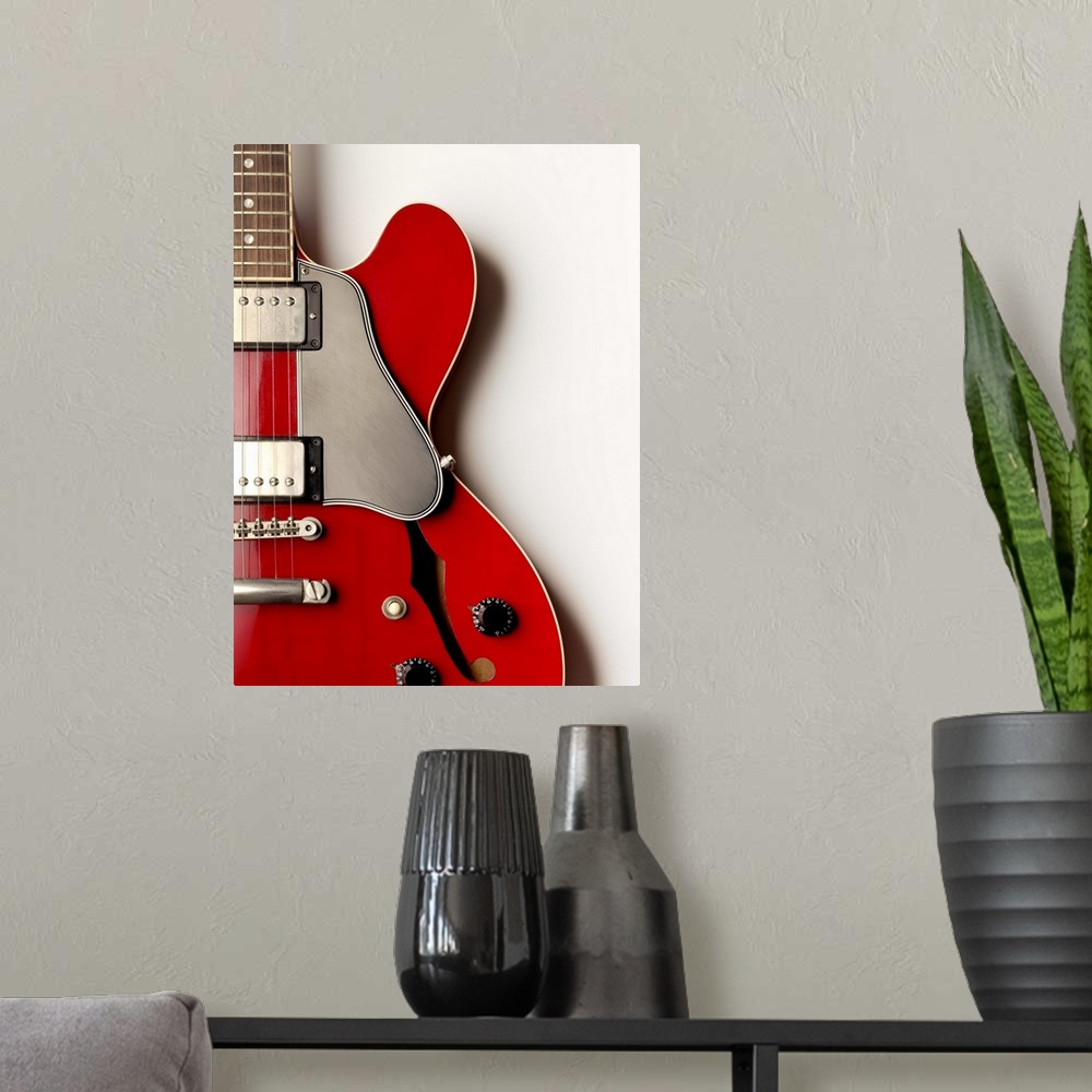 A modern room featuring A close up of an electric guitar showing its shape and design.