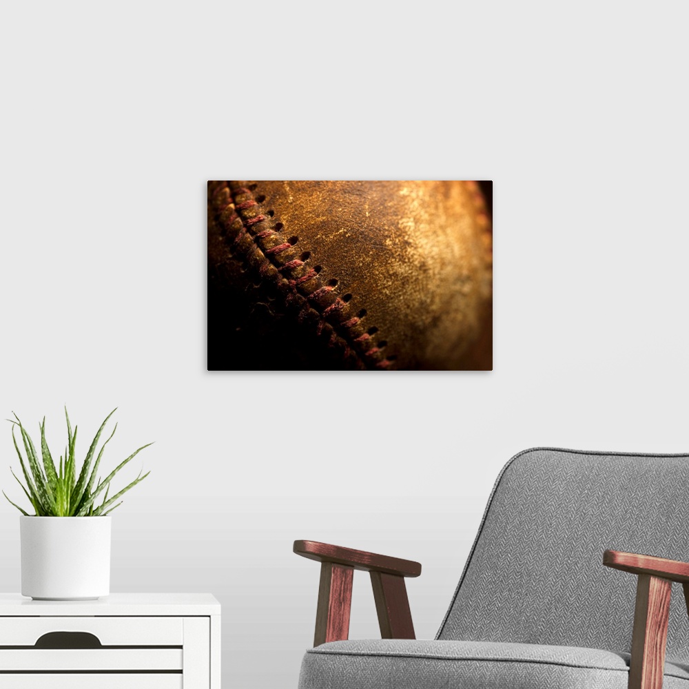 A modern room featuring A closeup of an old baseball. Shot with shallow depth of field.