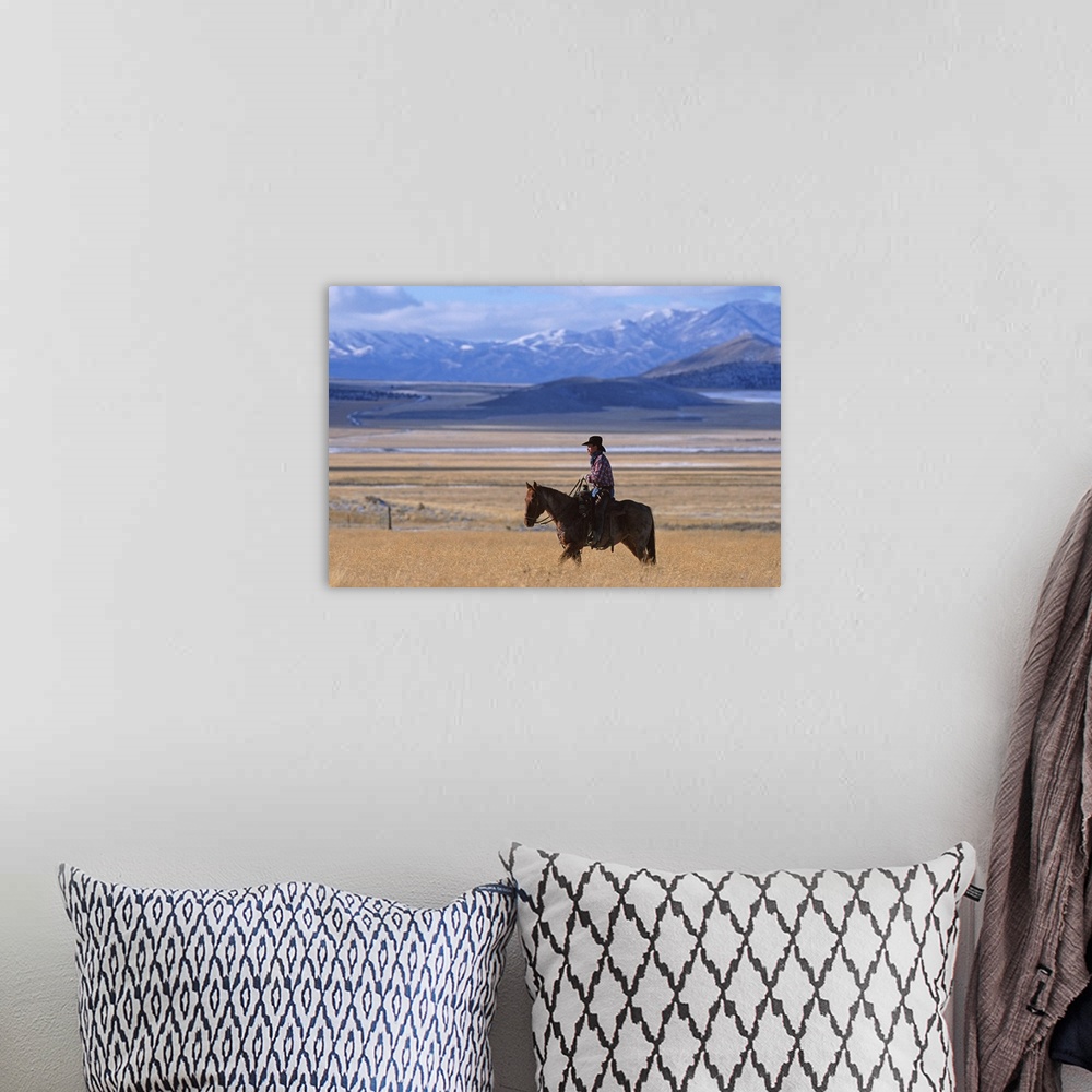 A bohemian room featuring a horizontal image of a cowboy riding his horse in a yellow field alone