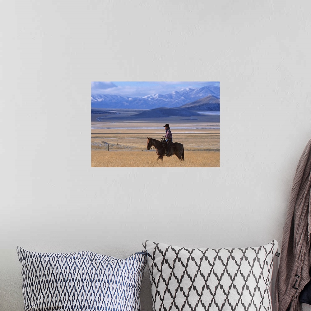 A bohemian room featuring a horizontal image of a cowboy riding his horse in a yellow field alone
