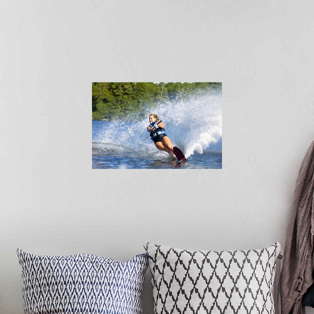 A bohemian room featuring A female water skier rips a turn causing a huge water spray while skiing on Cobbosseecontee Lake ...