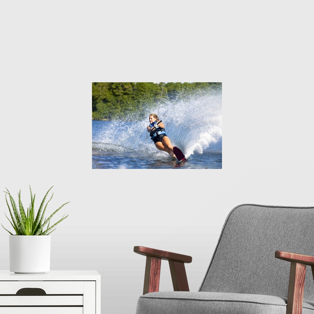 A modern room featuring A female water skier rips a turn causing a huge water spray while skiing on Cobbosseecontee Lake ...