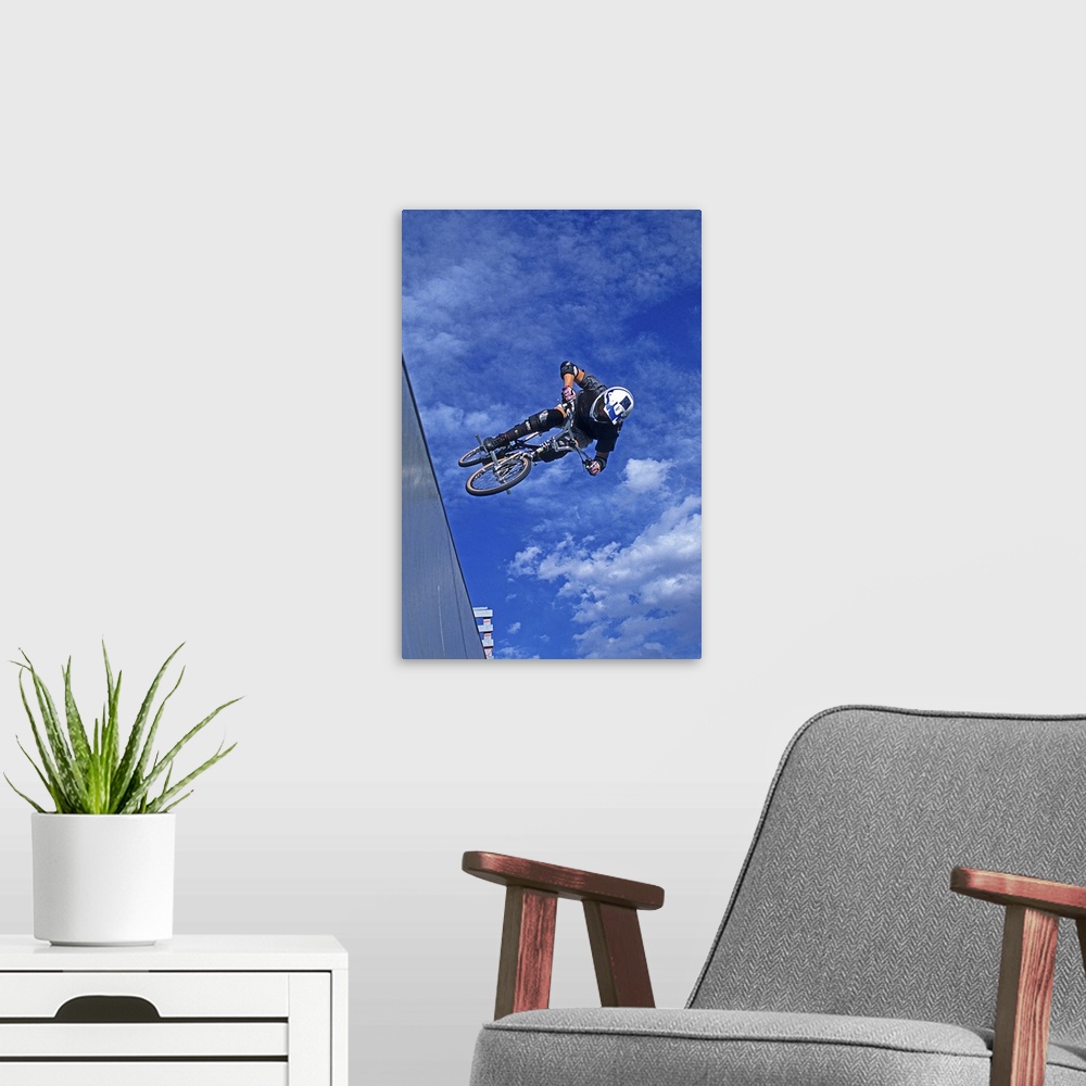 A modern room featuring A free skier jumps over a rocky and ice covered mountain.