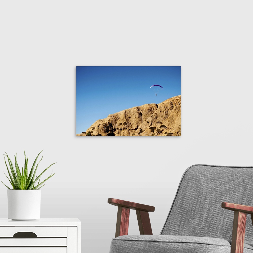 A modern room featuring A hang glider floats above the cliffs of Torrey Pines over La Jolla, California.