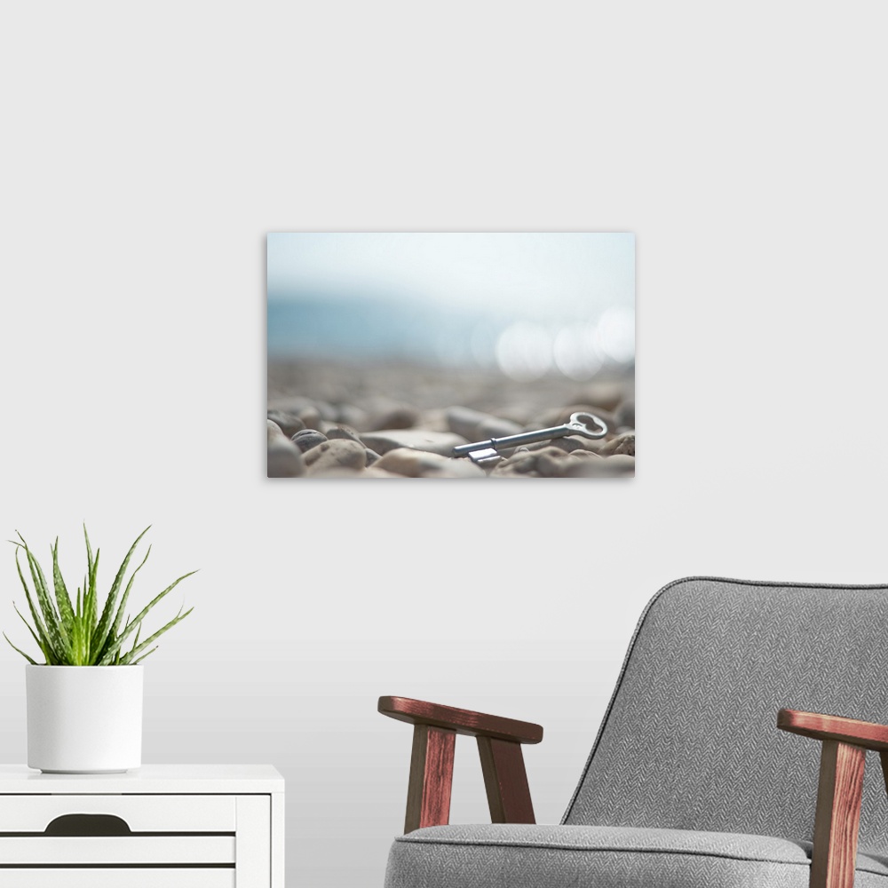 A modern room featuring a key left on the beach. Sea in bokeh bachground. Snake eye's view.