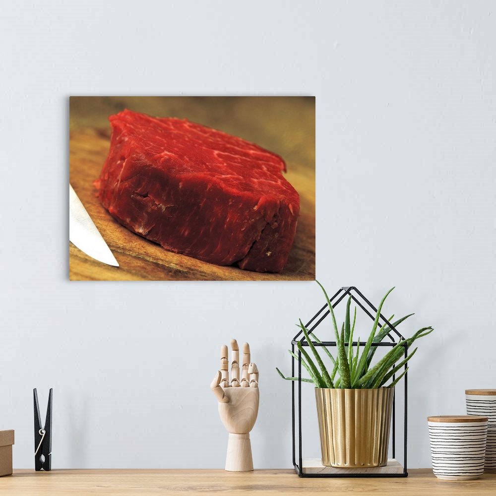 A bohemian room featuring a piece of red meat with a knife