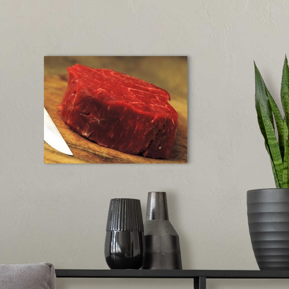 A modern room featuring a piece of red meat with a knife