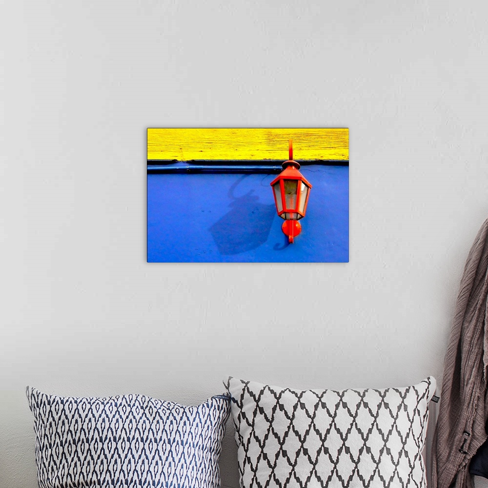A bohemian room featuring A red streetlamp on a blue and yellow wall.