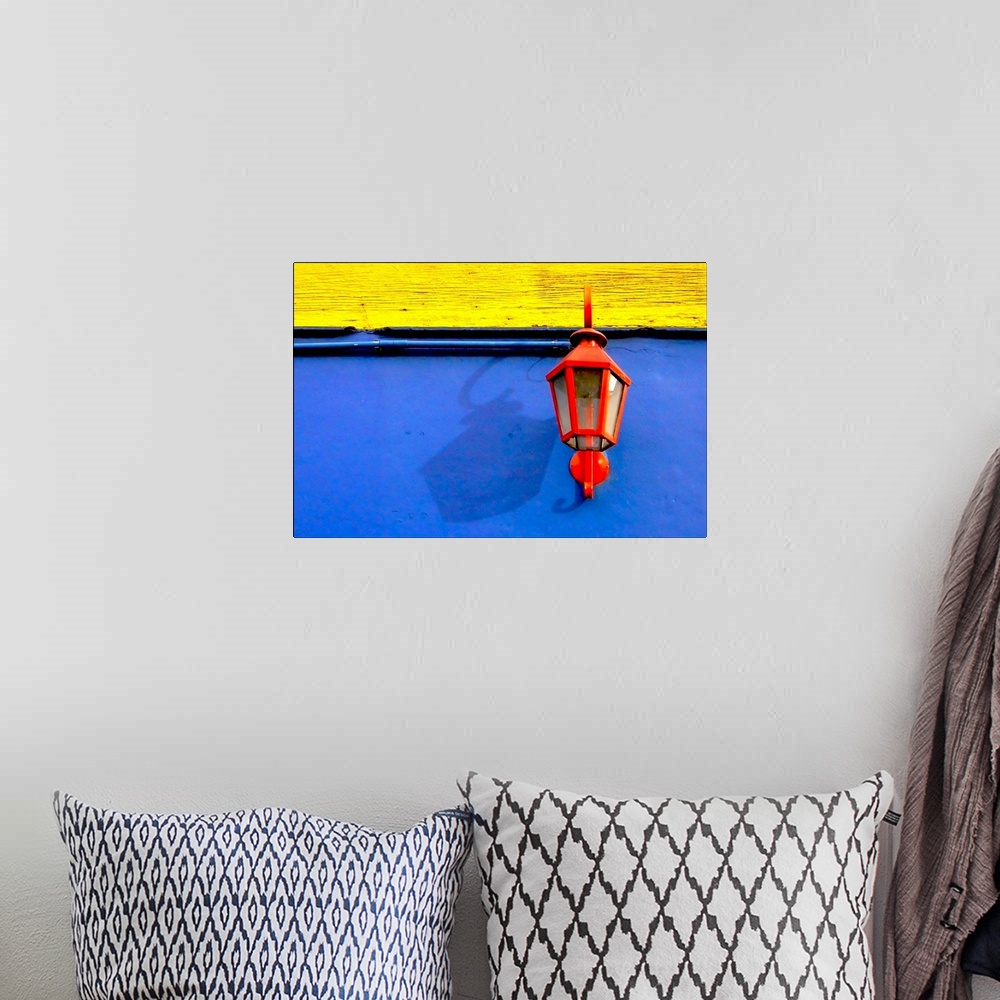 A bohemian room featuring A red streetlamp on a blue and yellow wall.