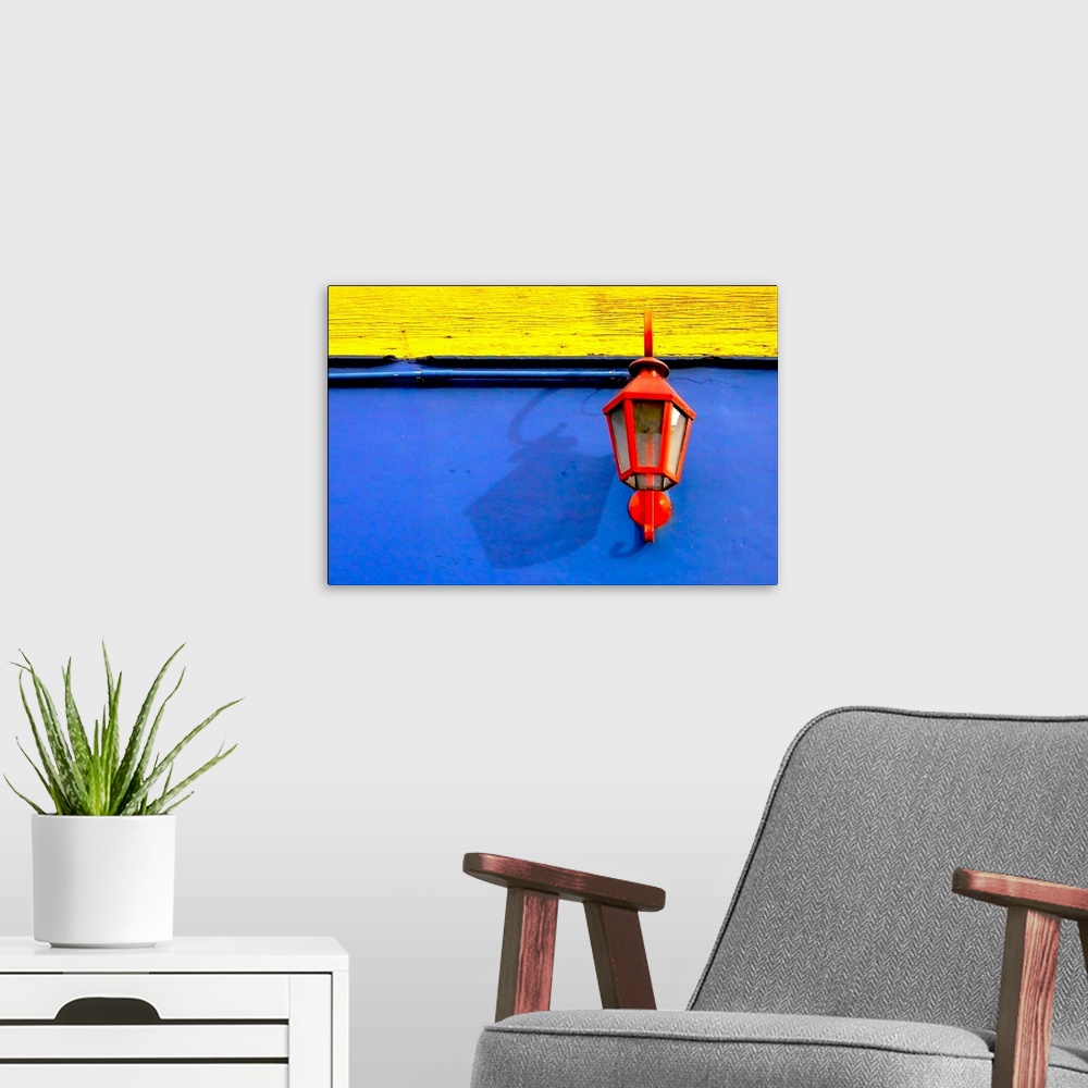 A modern room featuring A red streetlamp on a blue and yellow wall.