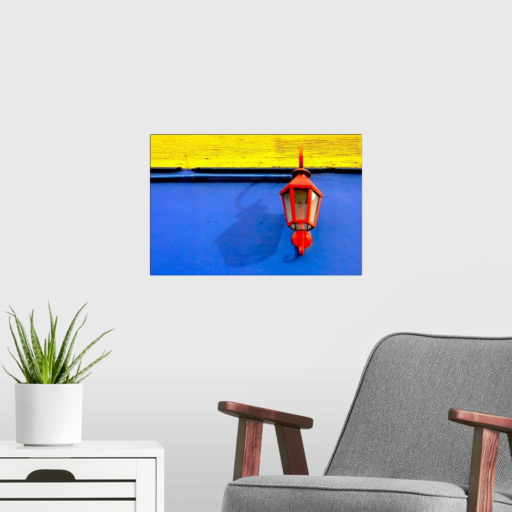A modern room featuring A red streetlamp on a blue and yellow wall.