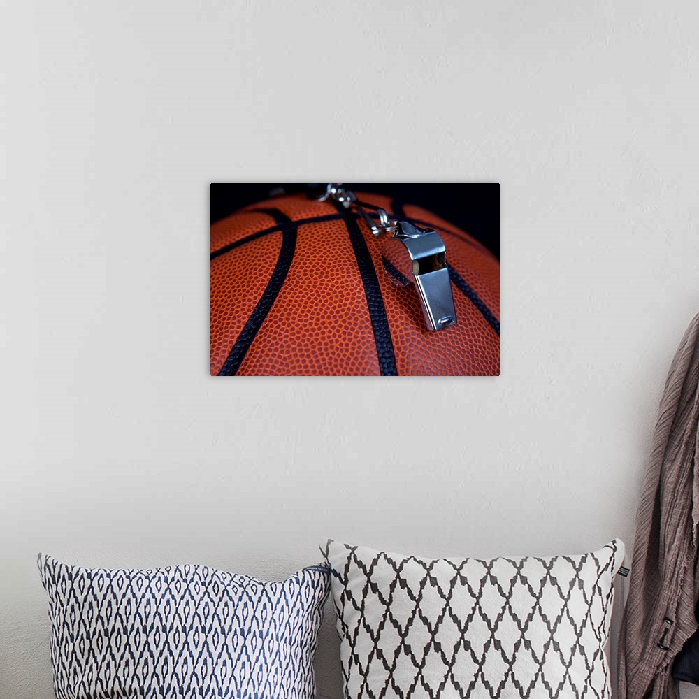 A bohemian room featuring A referee's whistle rests on top of a basketball.  Shot with Canon 5D Mark II.