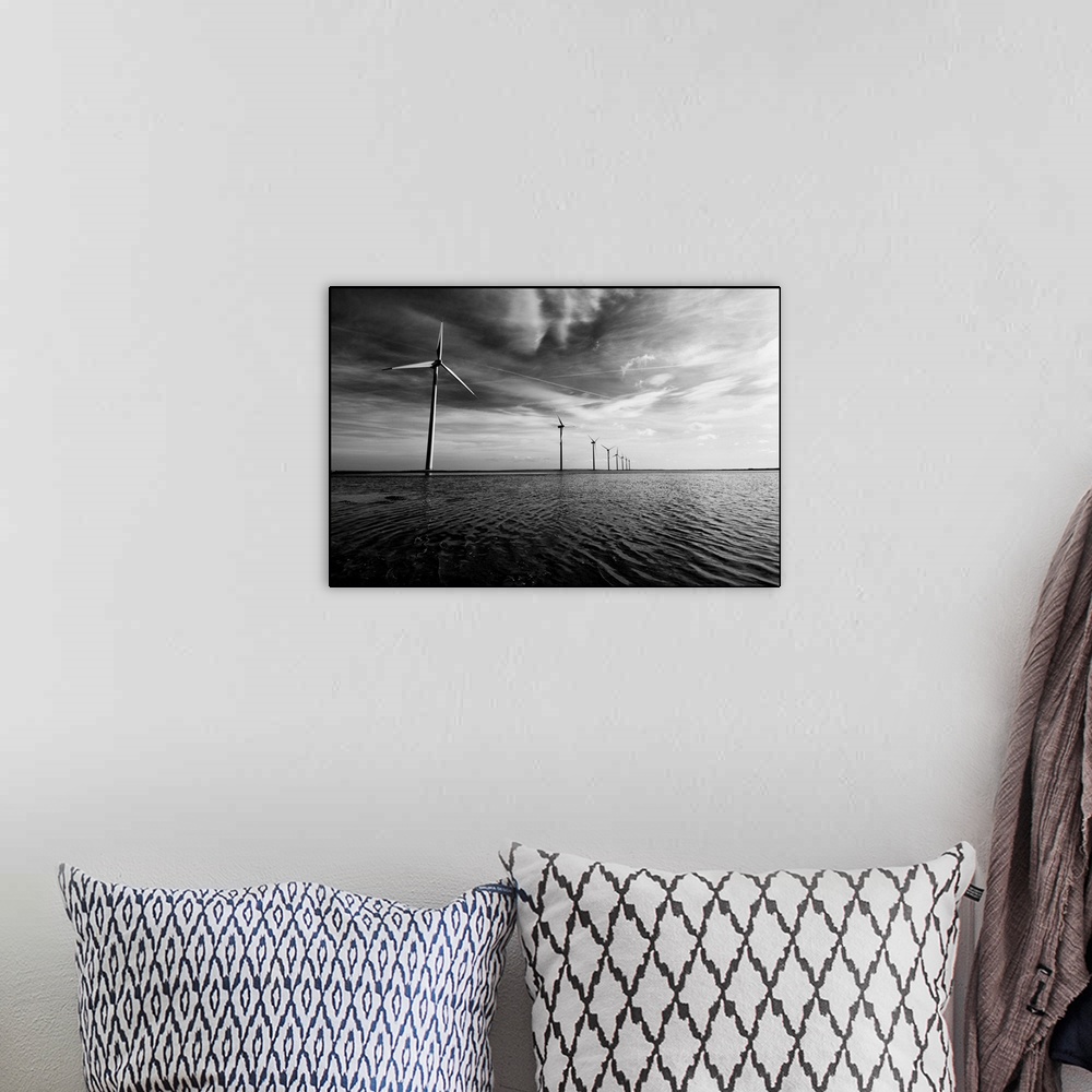 A bohemian room featuring A row of windmills in the sea, in the water with a dramatic sky and dramatic clouds overhead.Blac...
