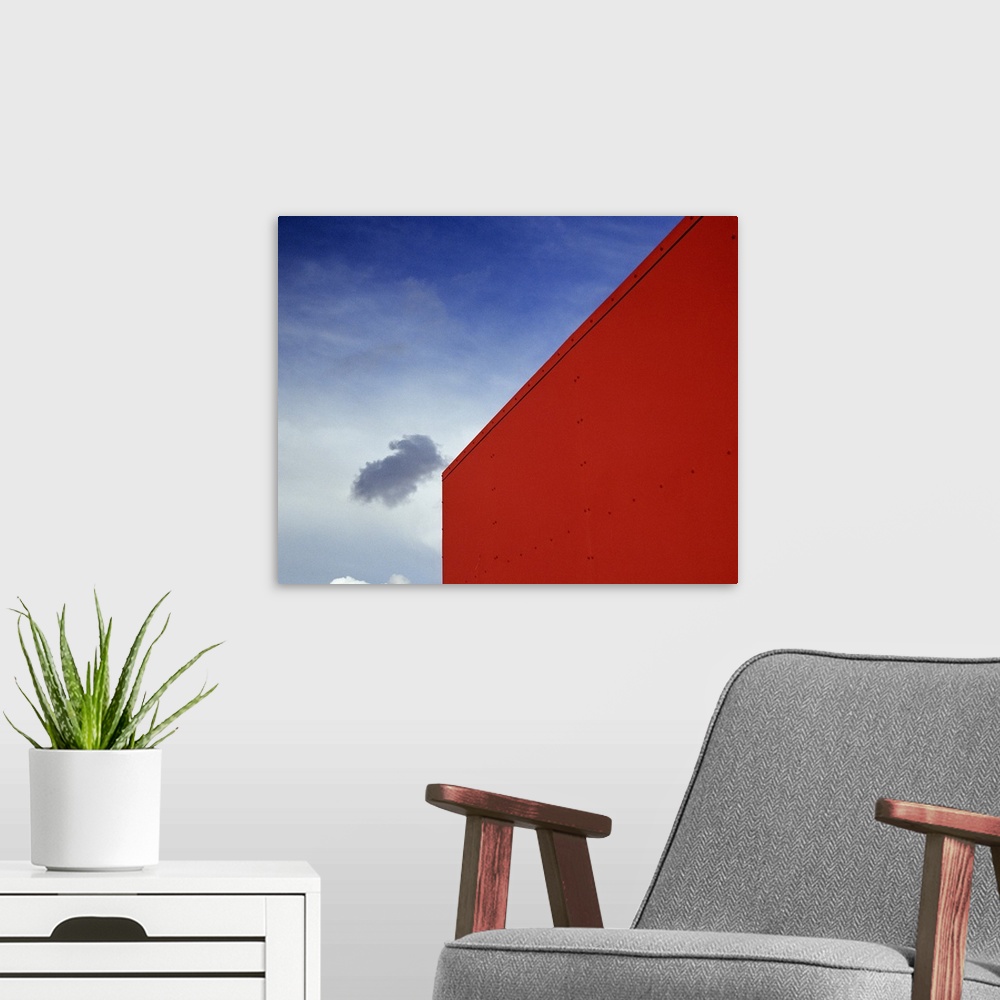 A modern room featuring A shadowed cloud floating through blue sky over the red corner of James John School.