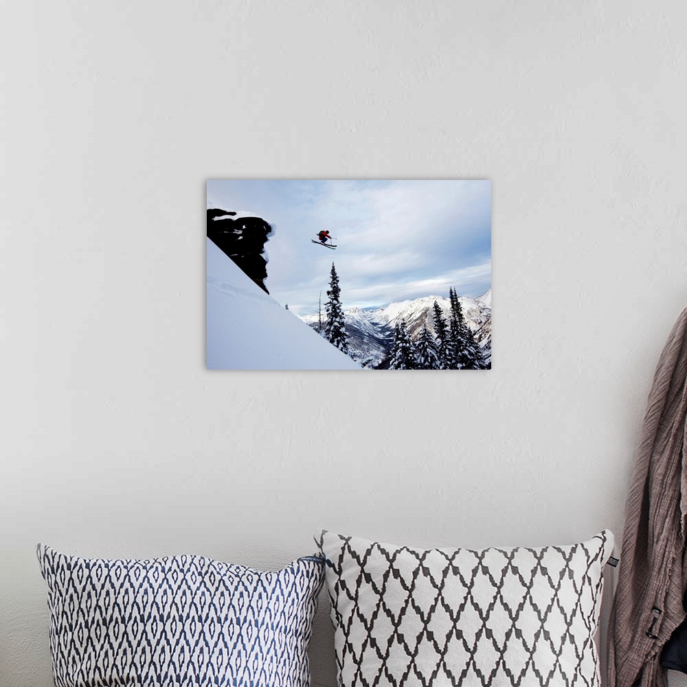 A bohemian room featuring A athletic skier jumping off a cliff in the backcountry in Colorado.