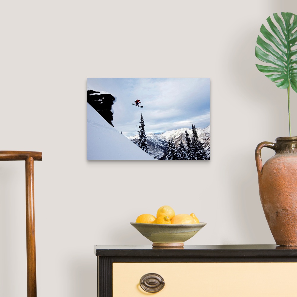 A traditional room featuring A athletic skier jumping off a cliff in the backcountry in Colorado.