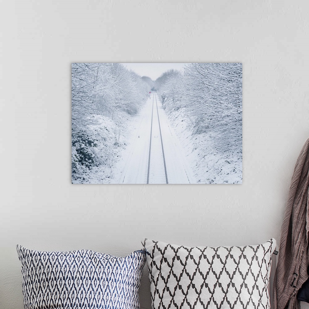 A bohemian room featuring A view overlooking a snow covered railway line as it vanishes past a lone red signal in the dista...