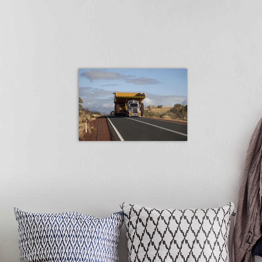 A bohemian room featuring A truck with a wide load driving on a desert highway