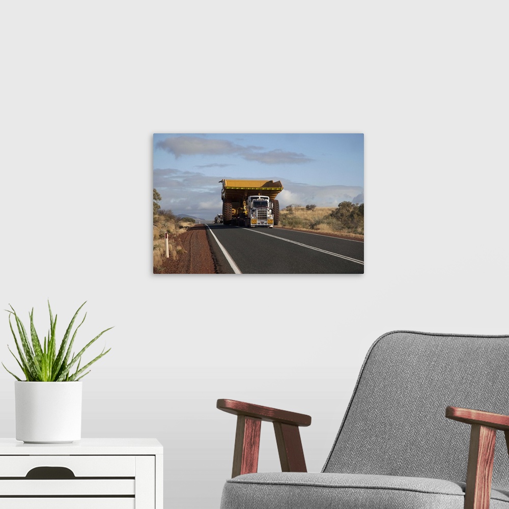 A modern room featuring A truck with a wide load driving on a desert highway