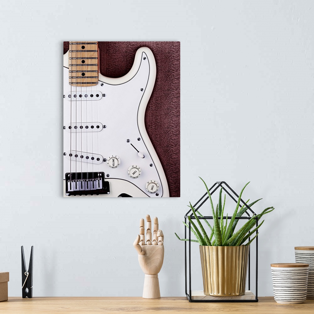 A bohemian room featuring A white electric guitar on a wooden surface