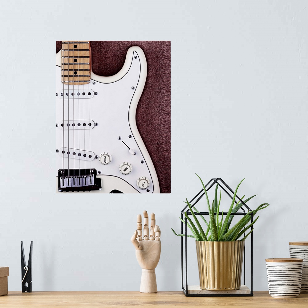 A bohemian room featuring A white electric guitar on a wooden surface