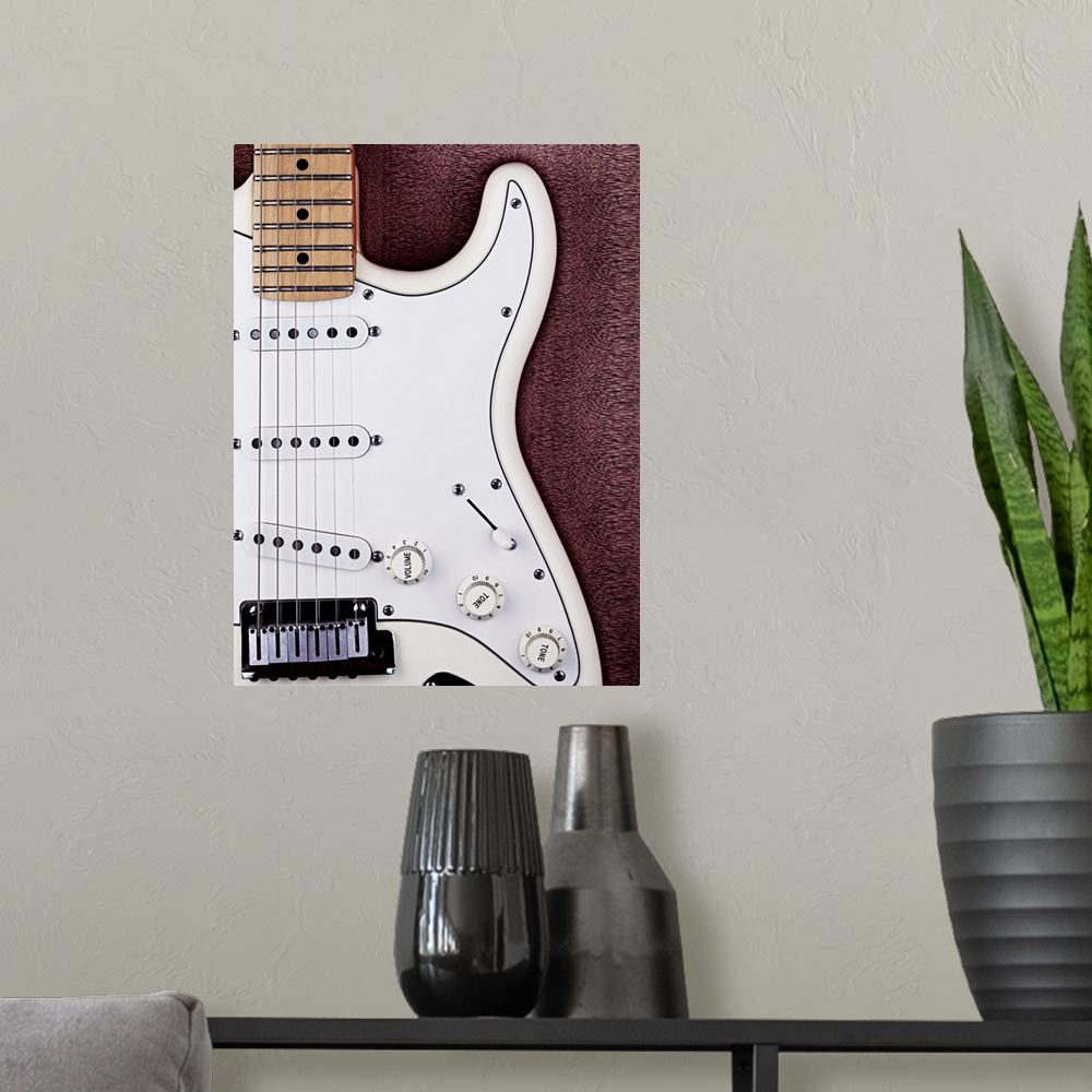 A modern room featuring A white electric guitar on a wooden surface