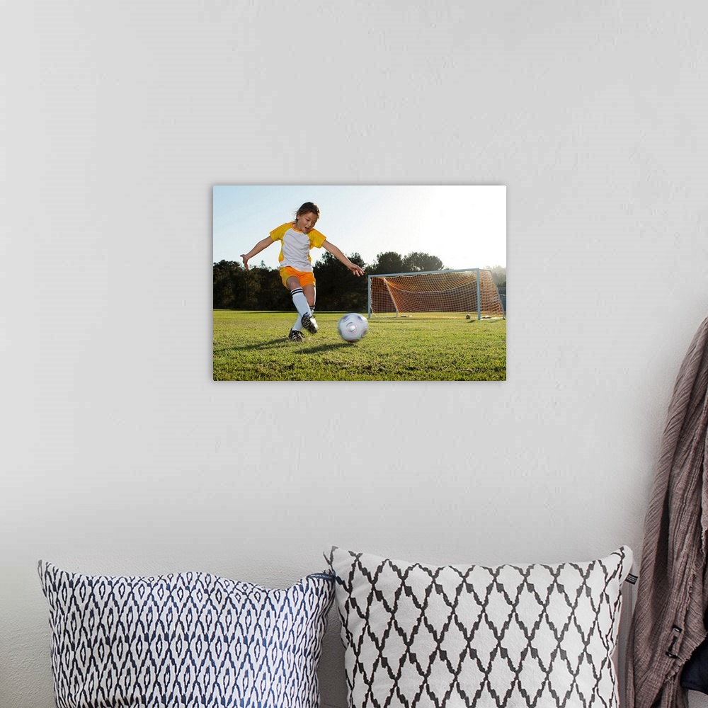A bohemian room featuring A young girl playing soccer on a soccer field in Los Angeles, California.
