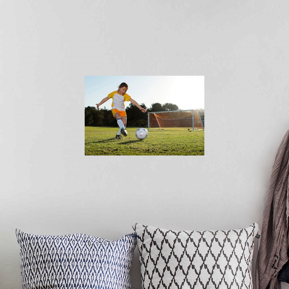 A bohemian room featuring A young girl playing soccer on a soccer field in Los Angeles, California.
