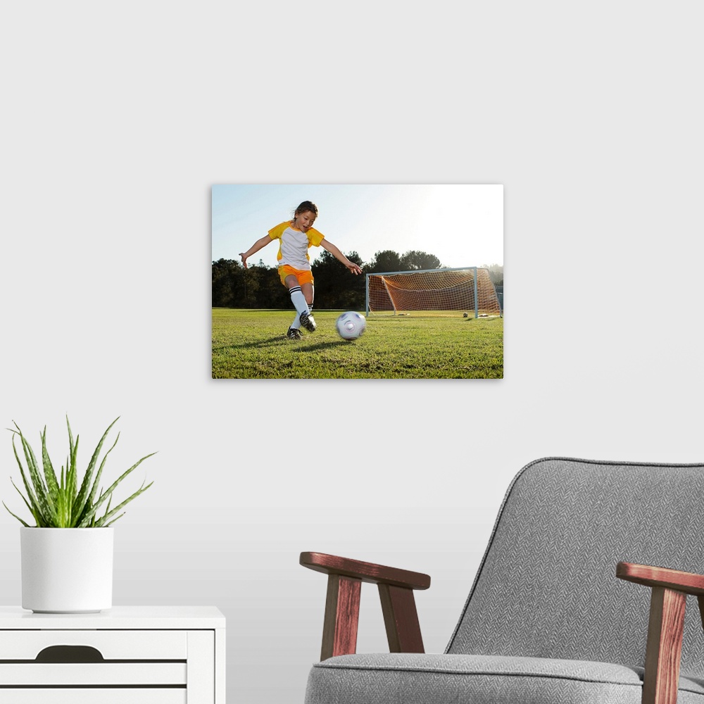 A modern room featuring A young girl playing soccer on a soccer field in Los Angeles, California.
