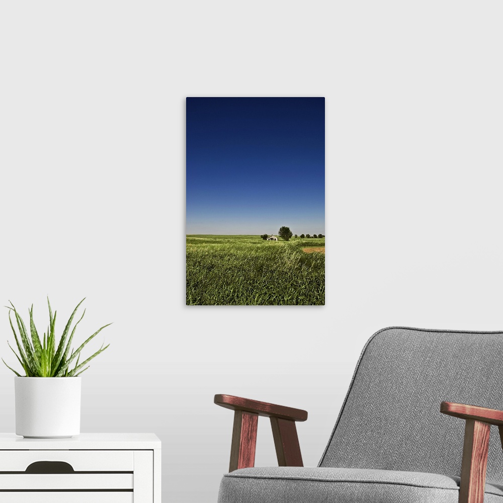 A modern room featuring A long-abandoned house sits in a field in the desolate grassy plains of southwest Oklahoma.