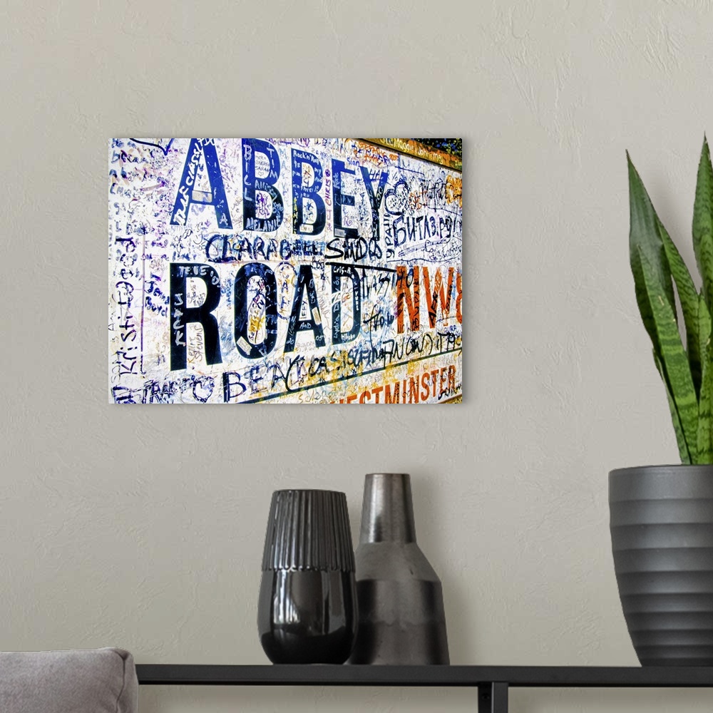 A modern room featuring Famous Abbey Road road sign covered with grafitti from Beatle fans