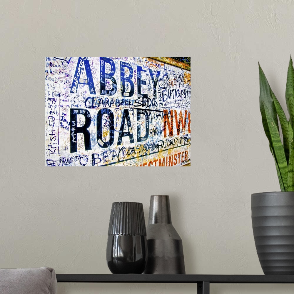 A modern room featuring Famous Abbey Road road sign covered with grafitti from Beatle fans