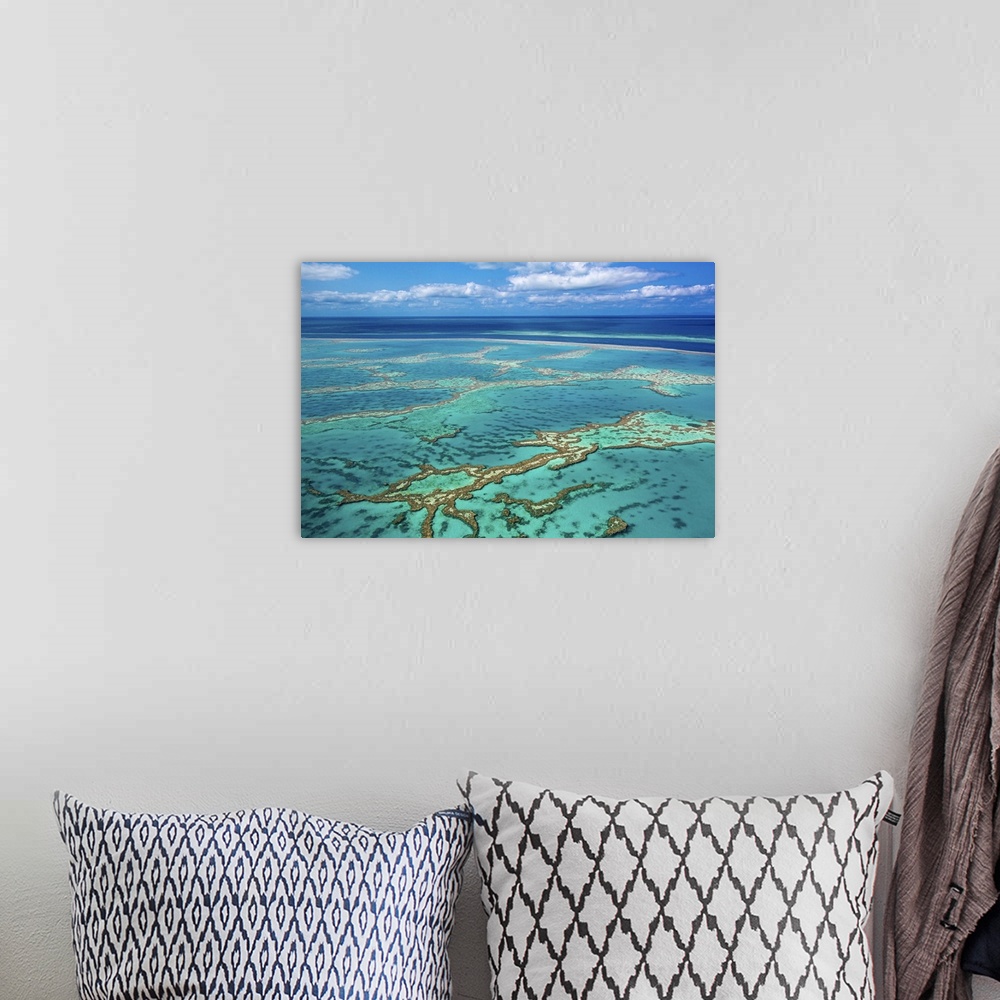 A bohemian room featuring Aerial photo of Great barrier reef showing reef area with some blue water and slightly cloudy sky...