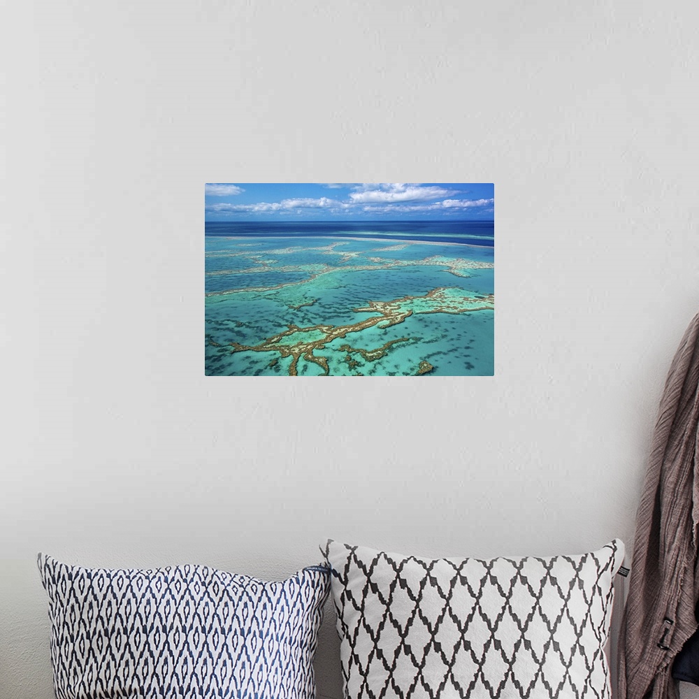 A bohemian room featuring Aerial photo of Great barrier reef showing reef area with some blue water and slightly cloudy sky...