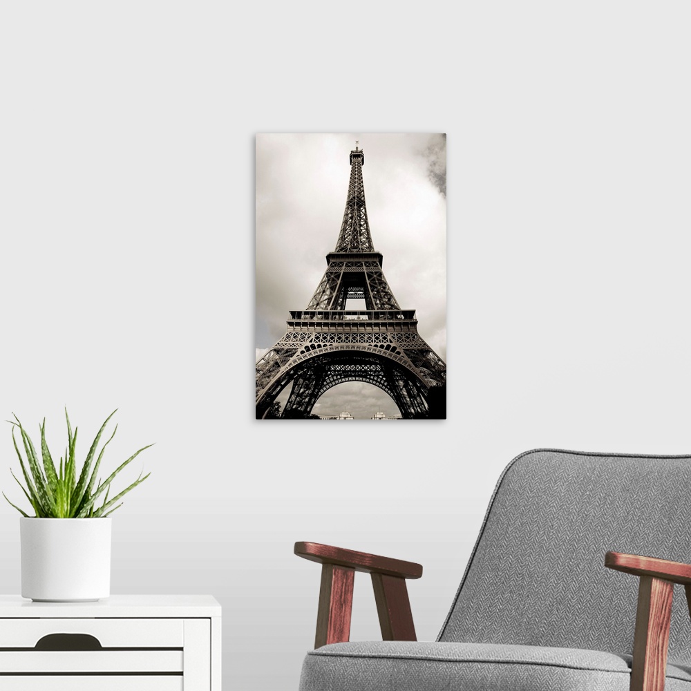 A modern room featuring Black and white photograph taken vertically looking up at the Eiffel Tower.