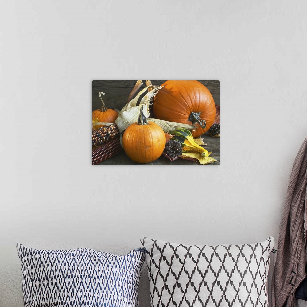 A bohemian room featuring An autumn arrangement of corn and pumpkins