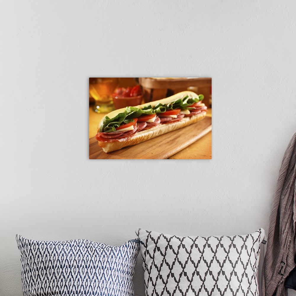 A bohemian room featuring An Italian sub sandwich with ham,salami,pepperoni, Swiss cheese, lettuce and tomato on a sandwich...