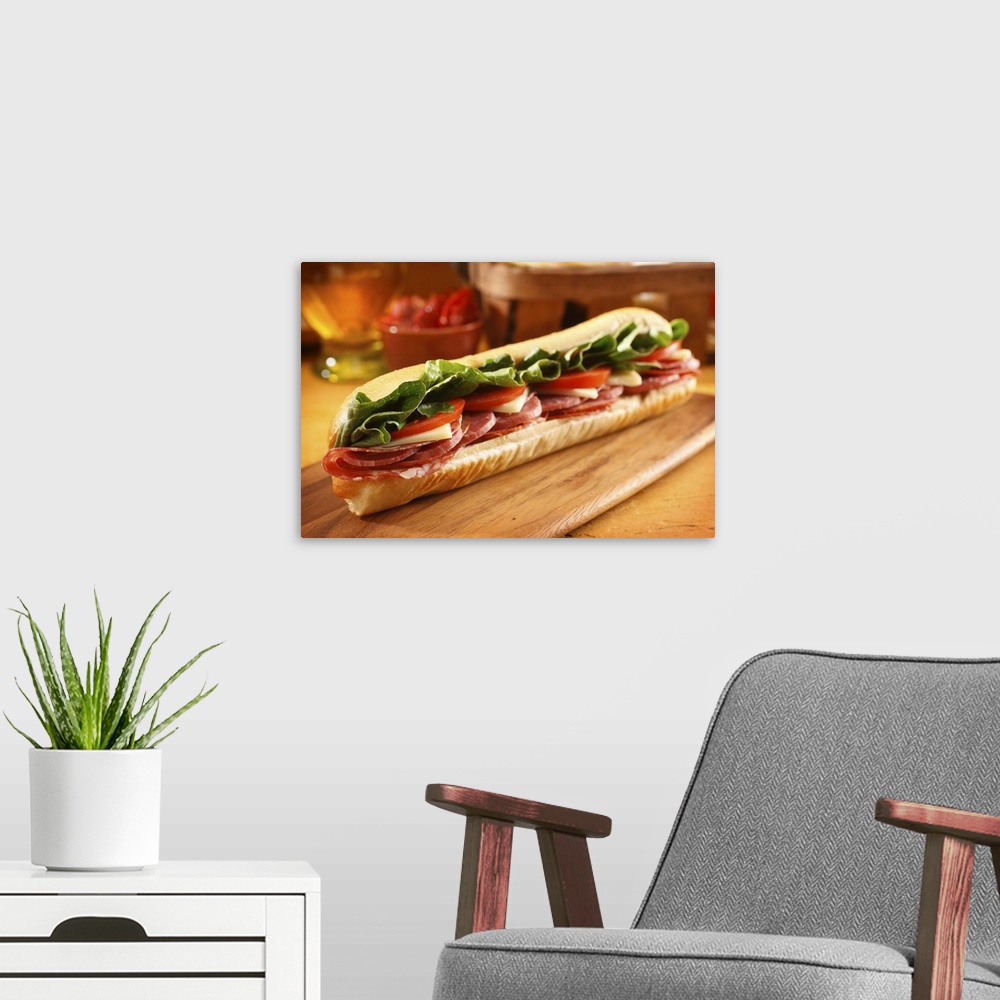 A modern room featuring An Italian sub sandwich with ham,salami,pepperoni, Swiss cheese, lettuce and tomato on a sandwich...