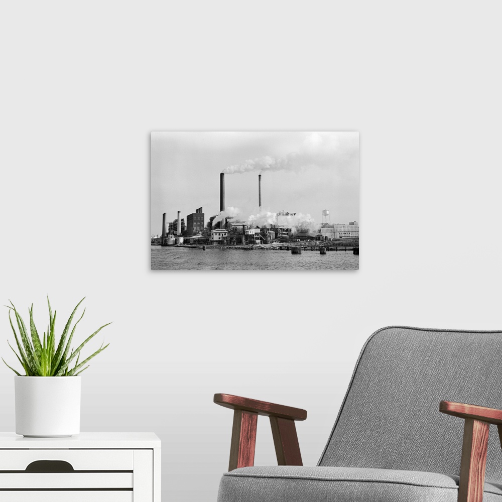 A modern room featuring View of Anchor Paper's box mill in Jacksonville, Florida. Factory with multiple smokestacks. Unda...