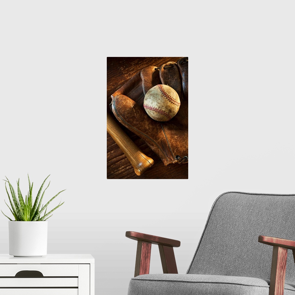 A modern room featuring Wall docor of a worn baseball laying on top of an old baseball mit with a wooden bat next to it.