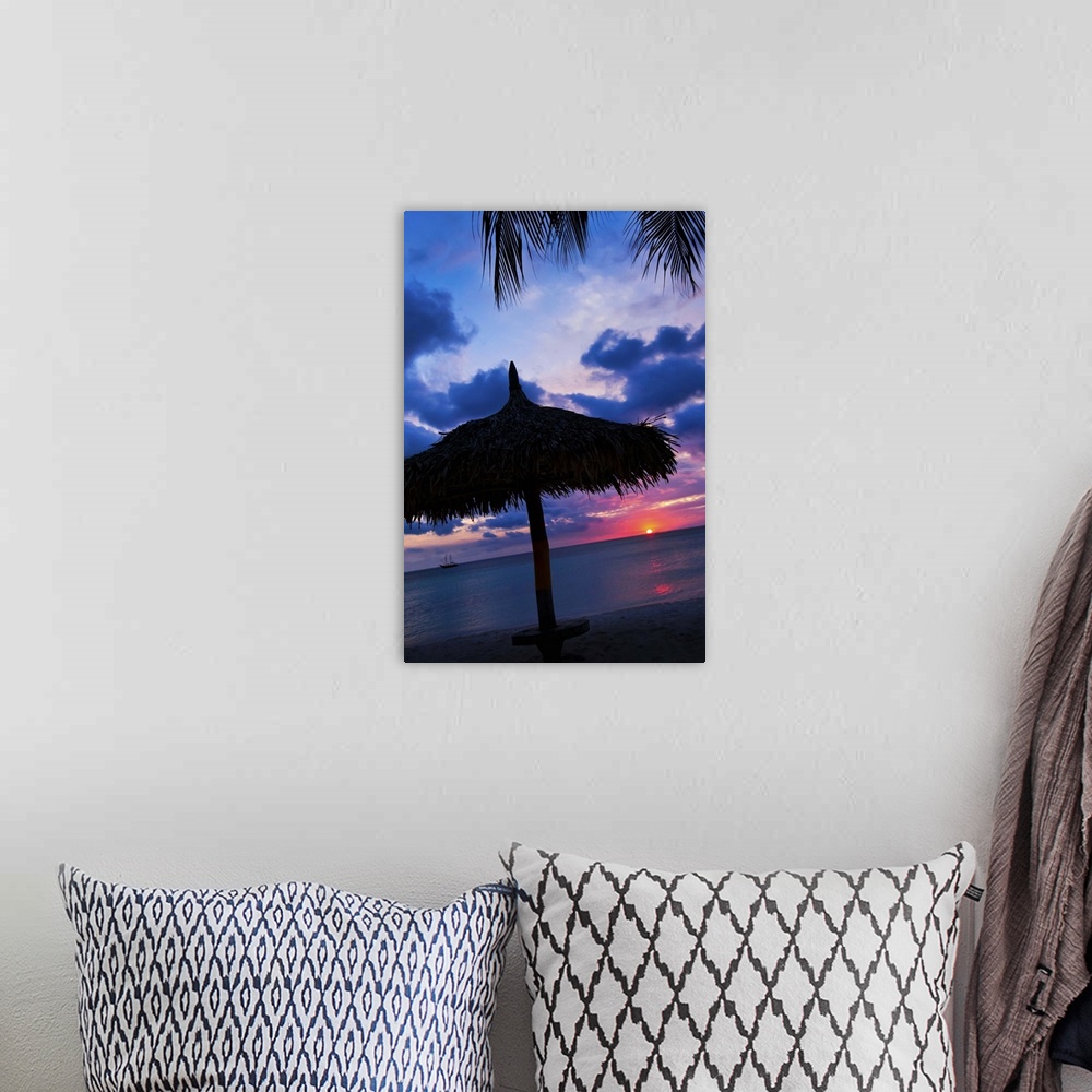 A bohemian room featuring Aruba, silhouette of palapa on beach at sunset