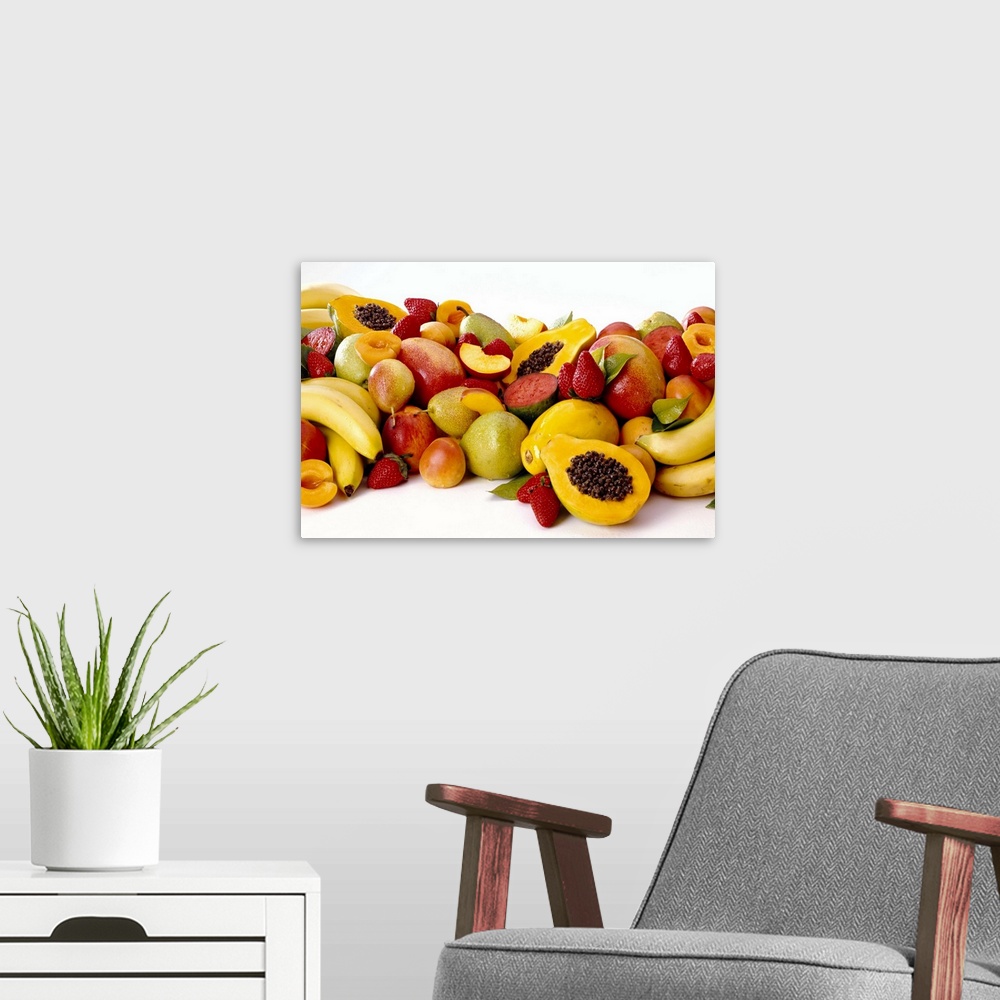 A modern room featuring Group of fresh fruit including bananas, papayas, strawberries, melons, mangoes, and apricots.